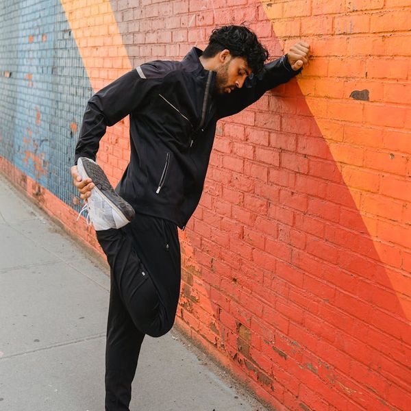 Person stretching energetically, coral color accents.